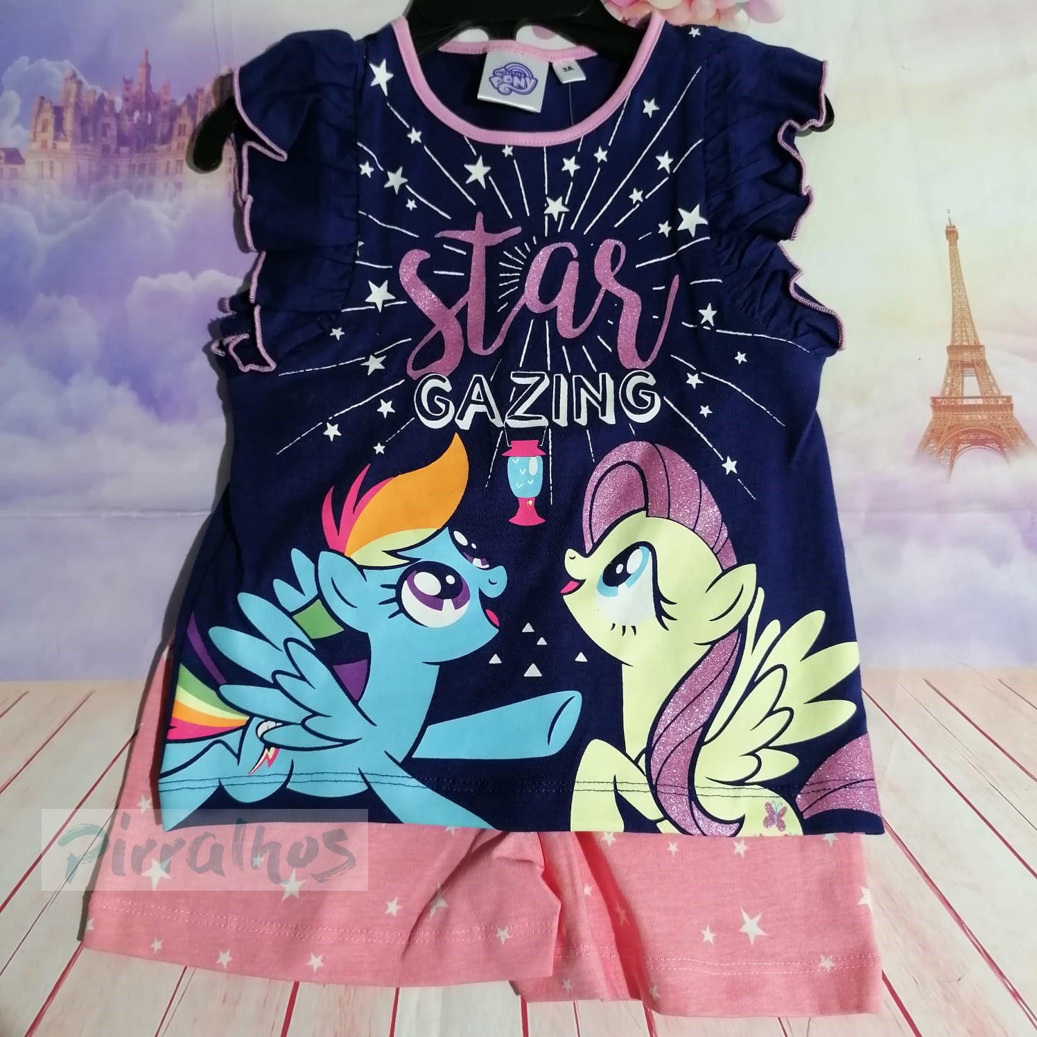 Conjunto infantil com camisola azul escura e calções rosa com padrão de estrelas