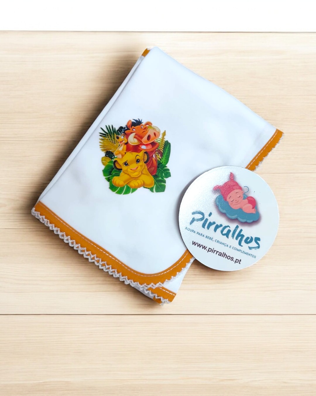 Fralda bordada com personagens do Rei Leão e etiqueta da marca Pirralhos