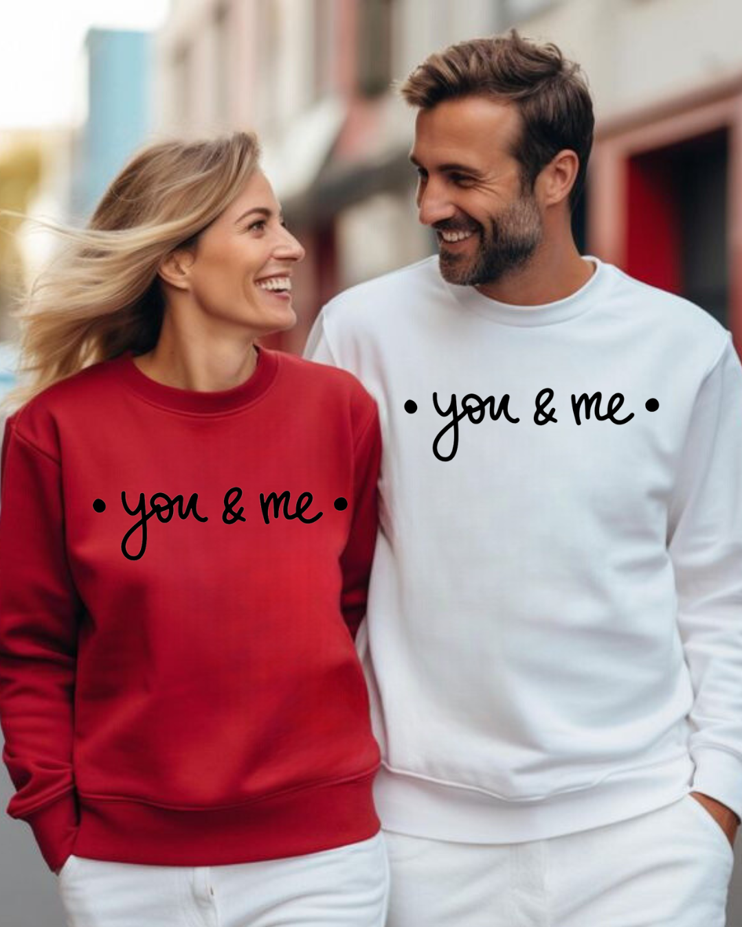 Homem e mulher sorrindo usando sweatshirts branco e vermelho com texto • you & me •