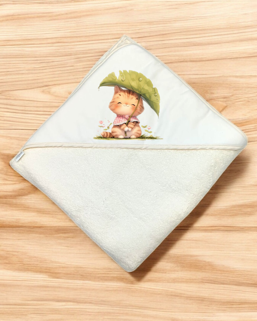 Toalha de banho branca para bebé com desenho de gato sob uma folha