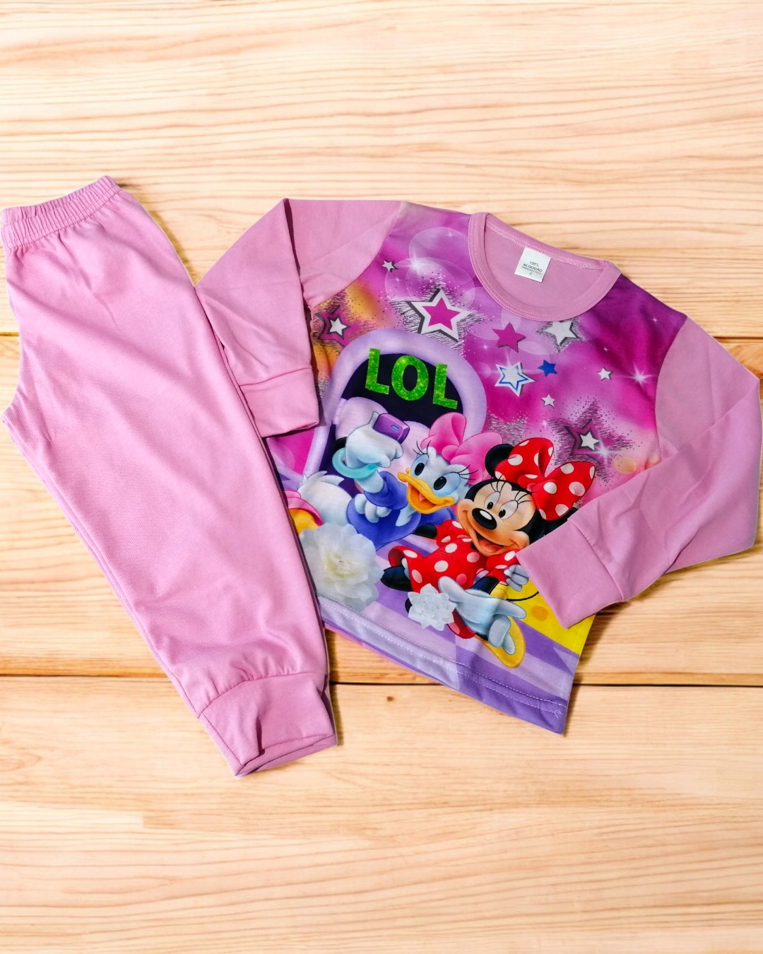 Conjunto de pijama infantil rosa com estampado Disney e calças lisas.