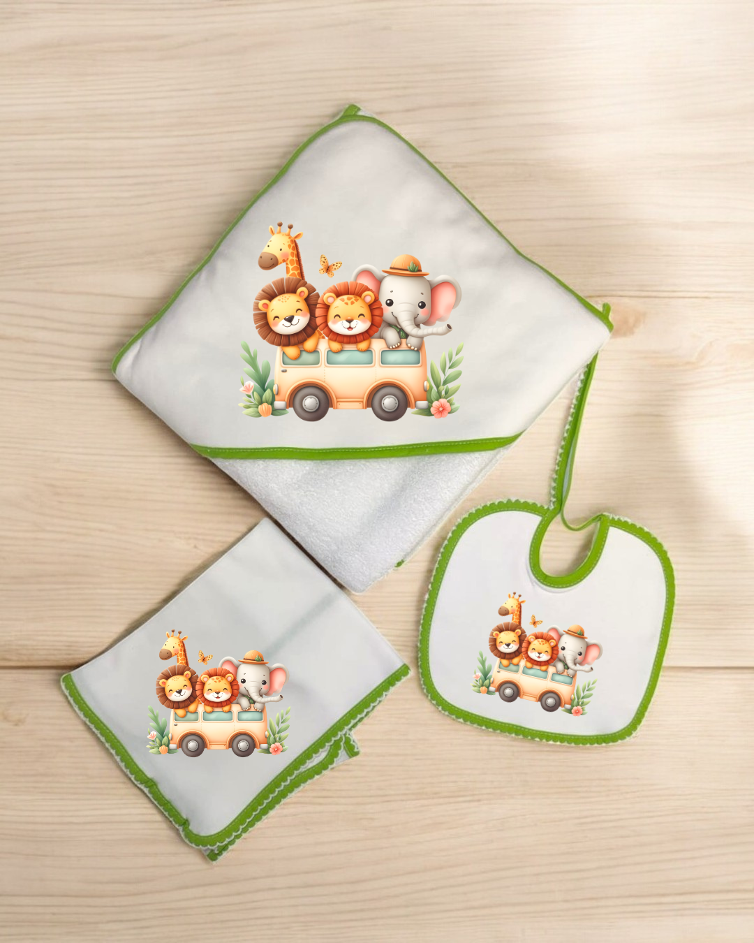Conjunto de toalha com capuz, babete e pano branco com bordas verdes e estampado de animais num autocarro.