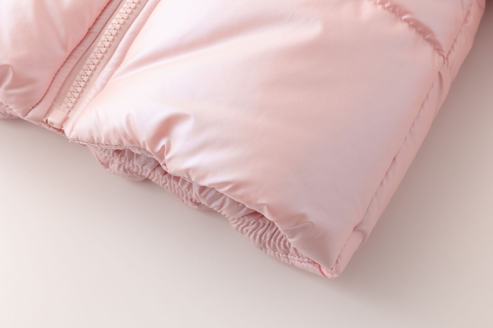 Casaco acolchoado rosa claro brilhante com fecho de correr e punho elástico.