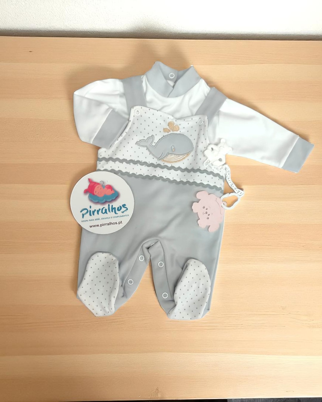 Macacão de bebé cinza e branco com baleia e elefante e etiqueta da marca Pirralhos