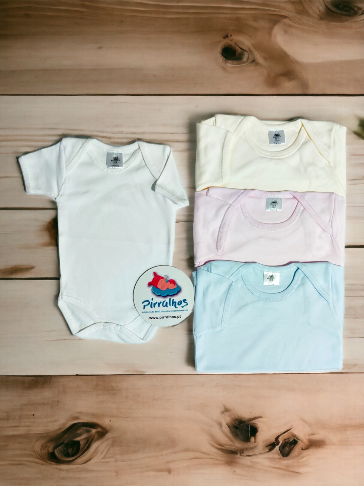 Bodys de bebé em várias cores com etiqueta e cartão promocional