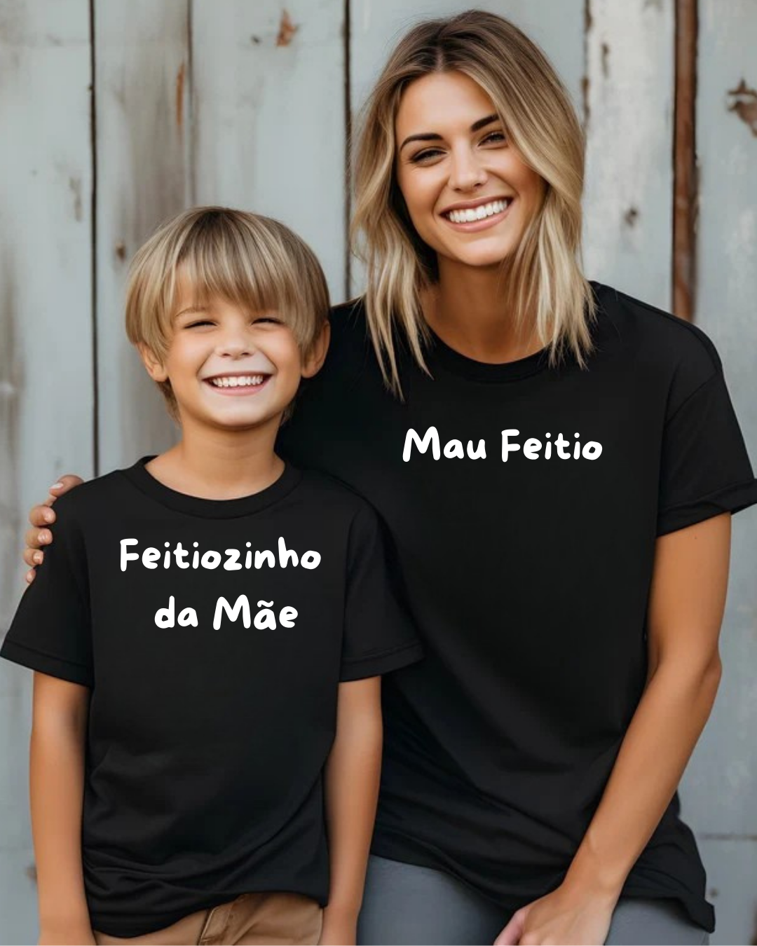 Criança e mulher sorridentes com t-shirts pretas com frases em branco, de pé junto a uma parede metálica cinzenta