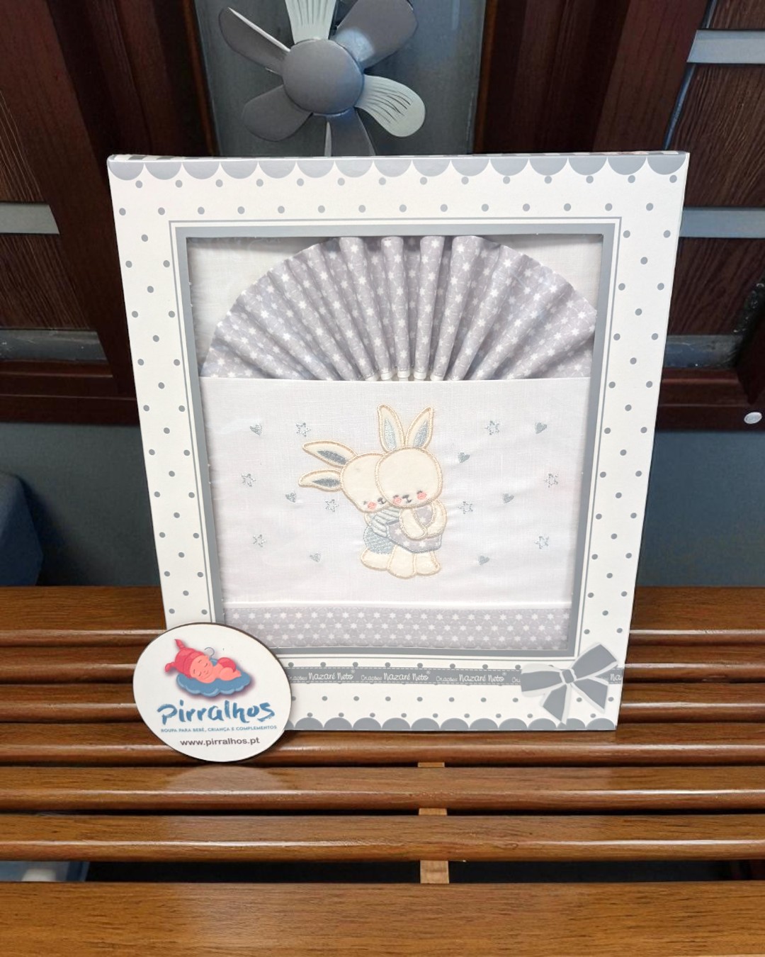 Fralda de bebé bordada com coelho em embalagem branca decorada com padrão de pontos cinzentos