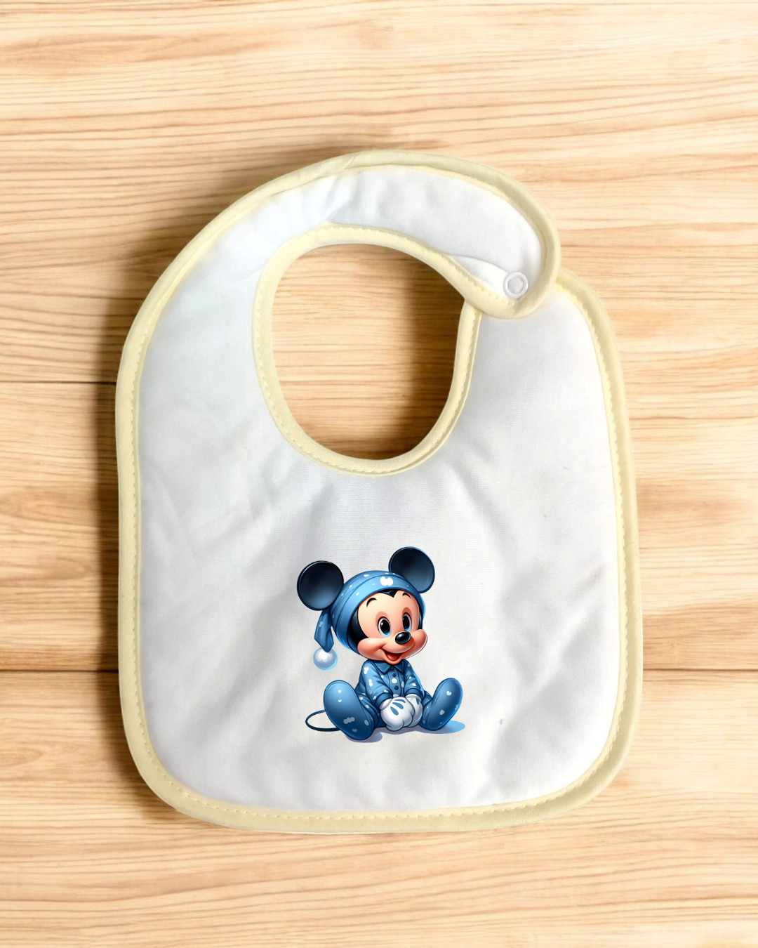 Babete branco com borda creme e estampa de personagem em pijama azul