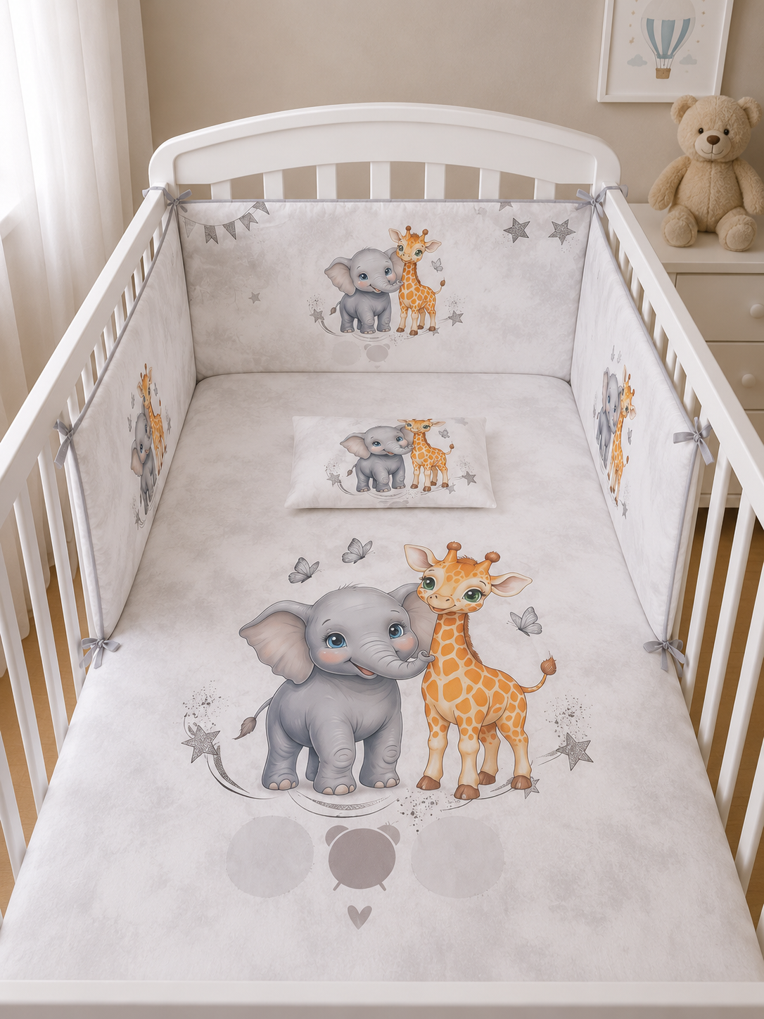 Berço branco com roupa de cama cinza claro com elefante e girafa cartoon.
