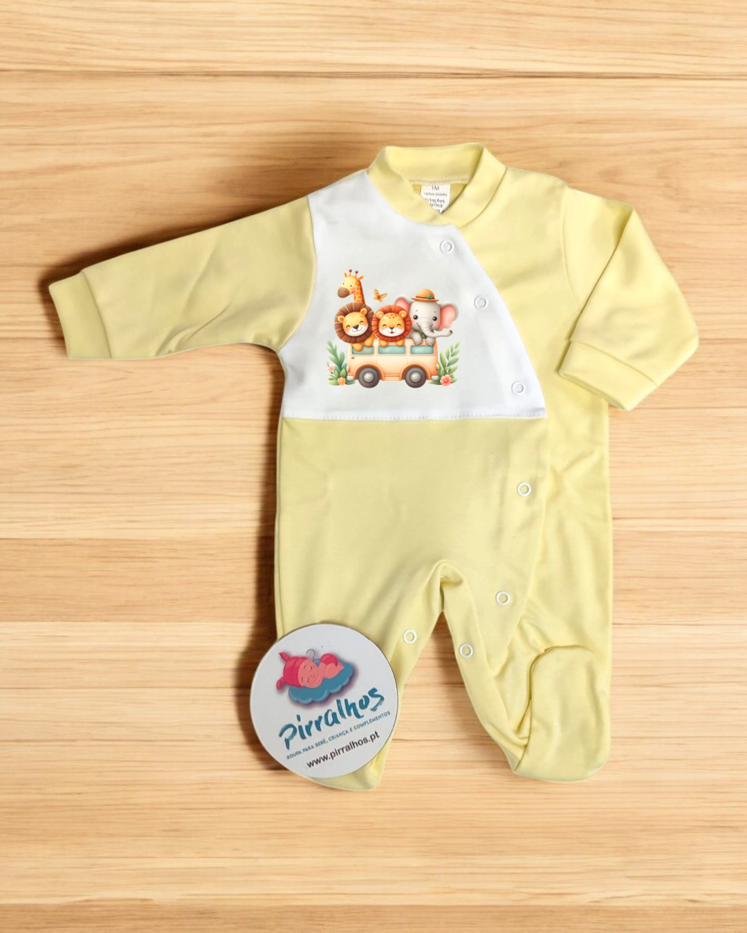 Pijama de bebé amarelo e branco com estampa de animais, com selo redondo ao lado