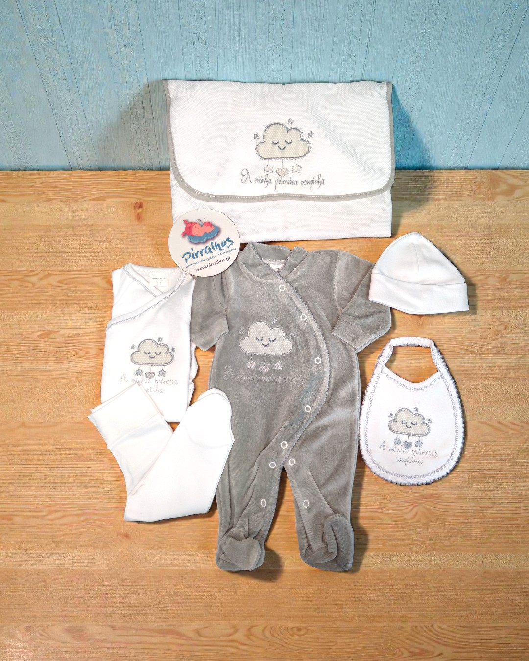 Conjunto de roupa de bebé com bordado de nuvem e texto A minha primeira roupinha