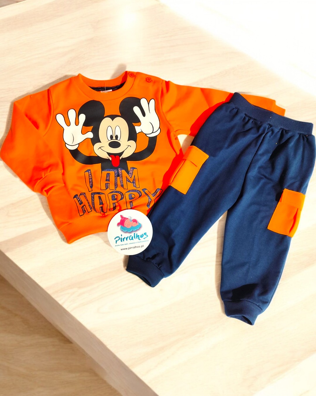 Conjunto infantil com camisola laranja do Mickey Mouse e calças azuis com detalhes laranja
