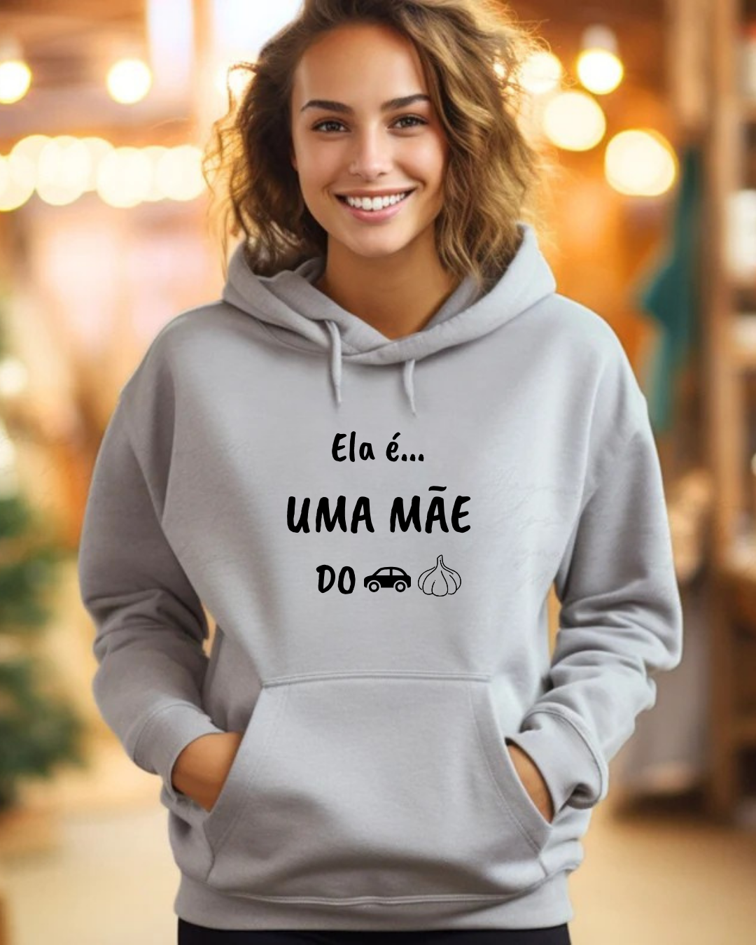 Mulher com sweatshirt cinza com texto e símbolos em preto num ambiente iluminado
