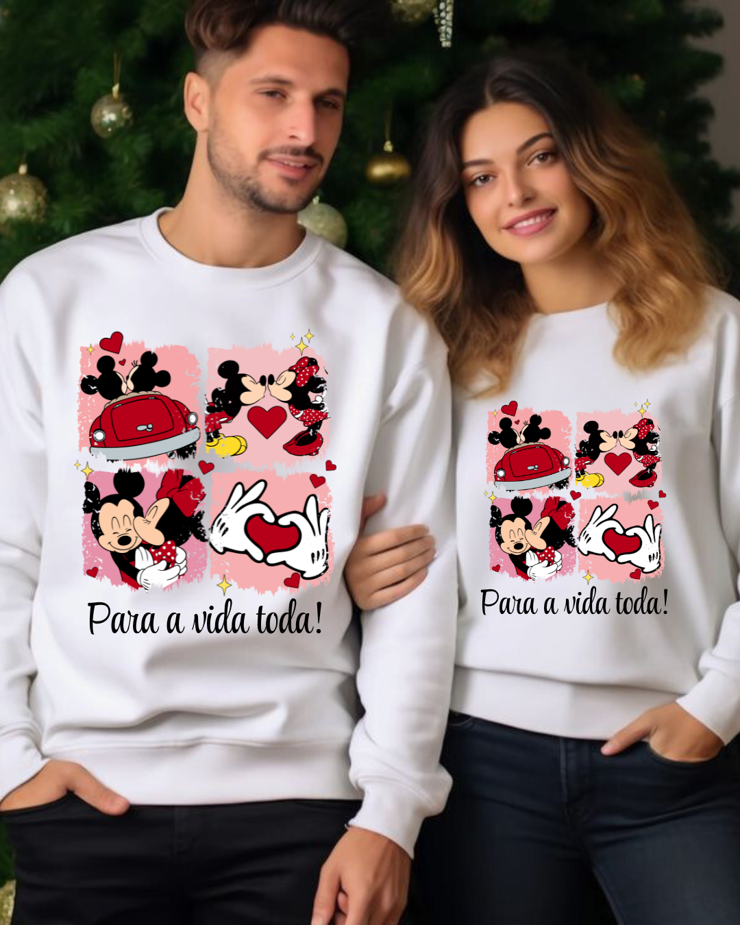 Casal com sweatshirts brancas de Mickey e Minnie com texto 'Para a vida toda!' em fundo de árvore de Natal