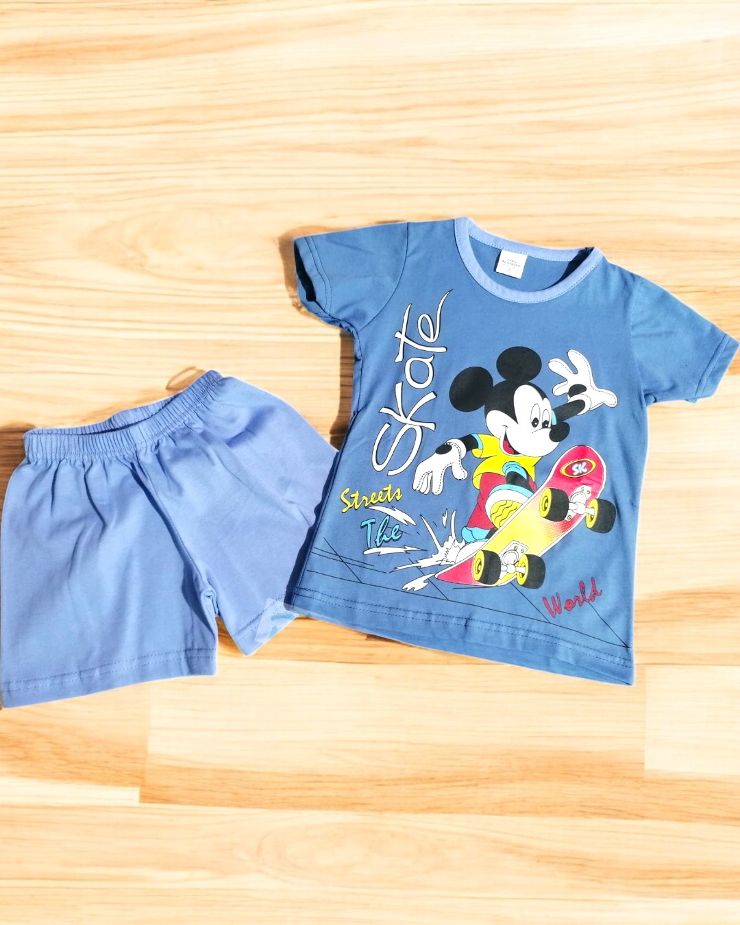 Conjunto infantil azul com t-shirt do Mickey Mouse em skate e calções azuis