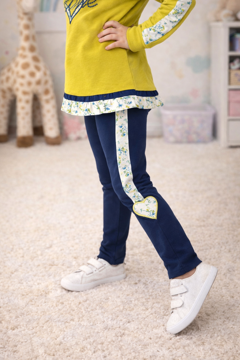 calças de criança azul com faixa branca estampada e coração, t-shirt amarela e sapatilhas brancas