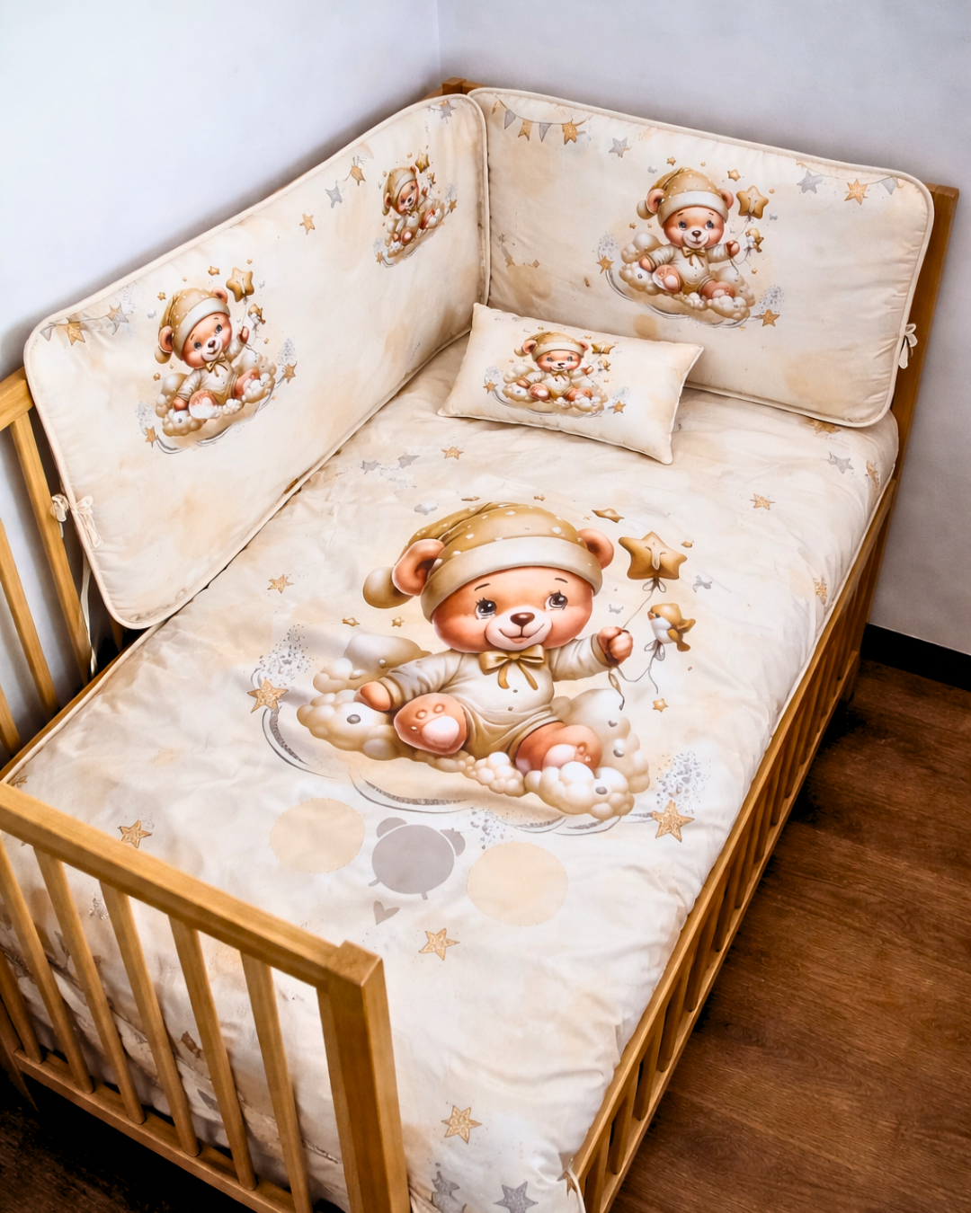 Berço de madeira com roupa de cama bege com estampado de ursinho em pijama