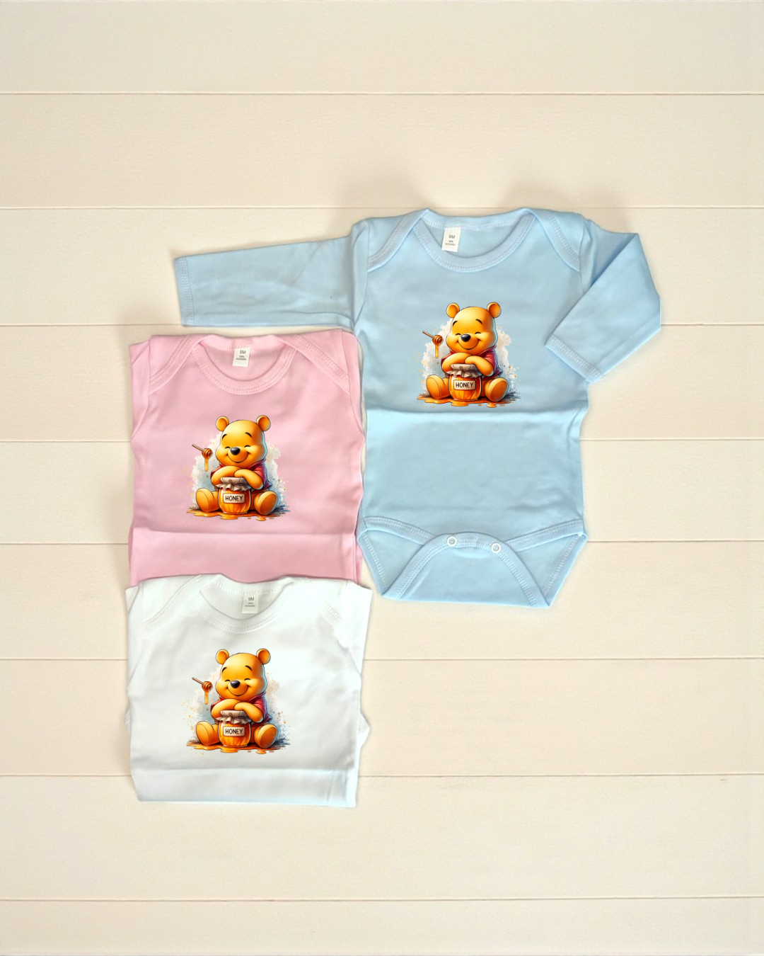 Bodies de bebé azul, rosa e branco com estampa do Ursinho Pooh e pote de mel HONEY