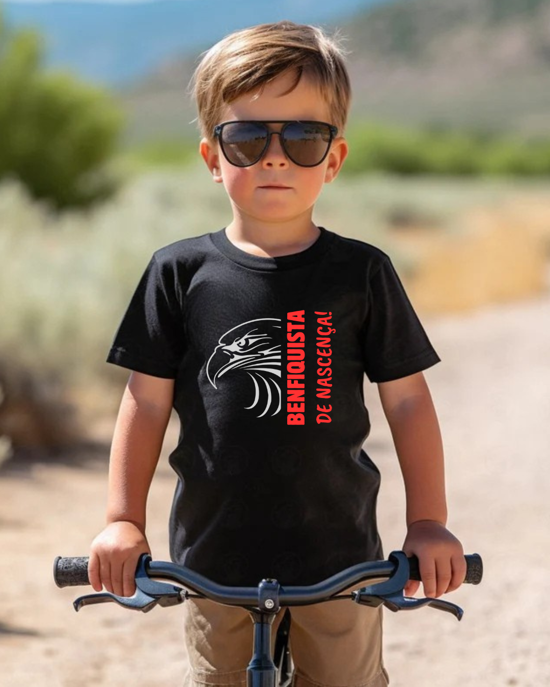 Criança com camiseta preta e óculos escuros segurando bicicleta ao ar livre