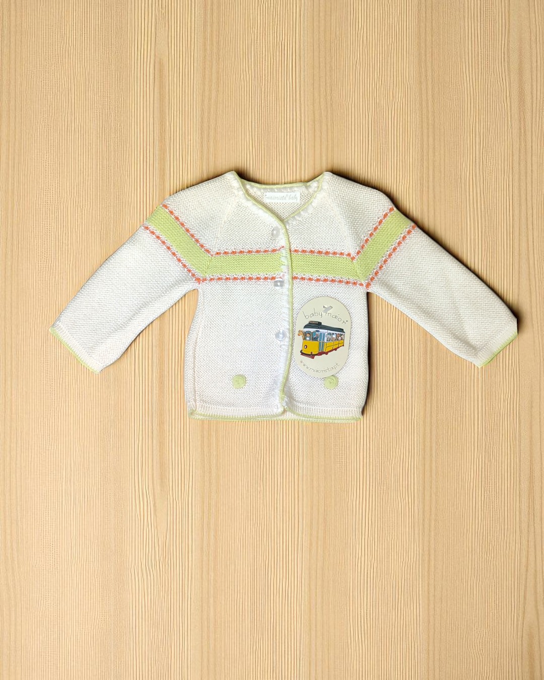 Casaco de bebê branco com riscas verdes e vermelhas e desenho de elétrico amarelo