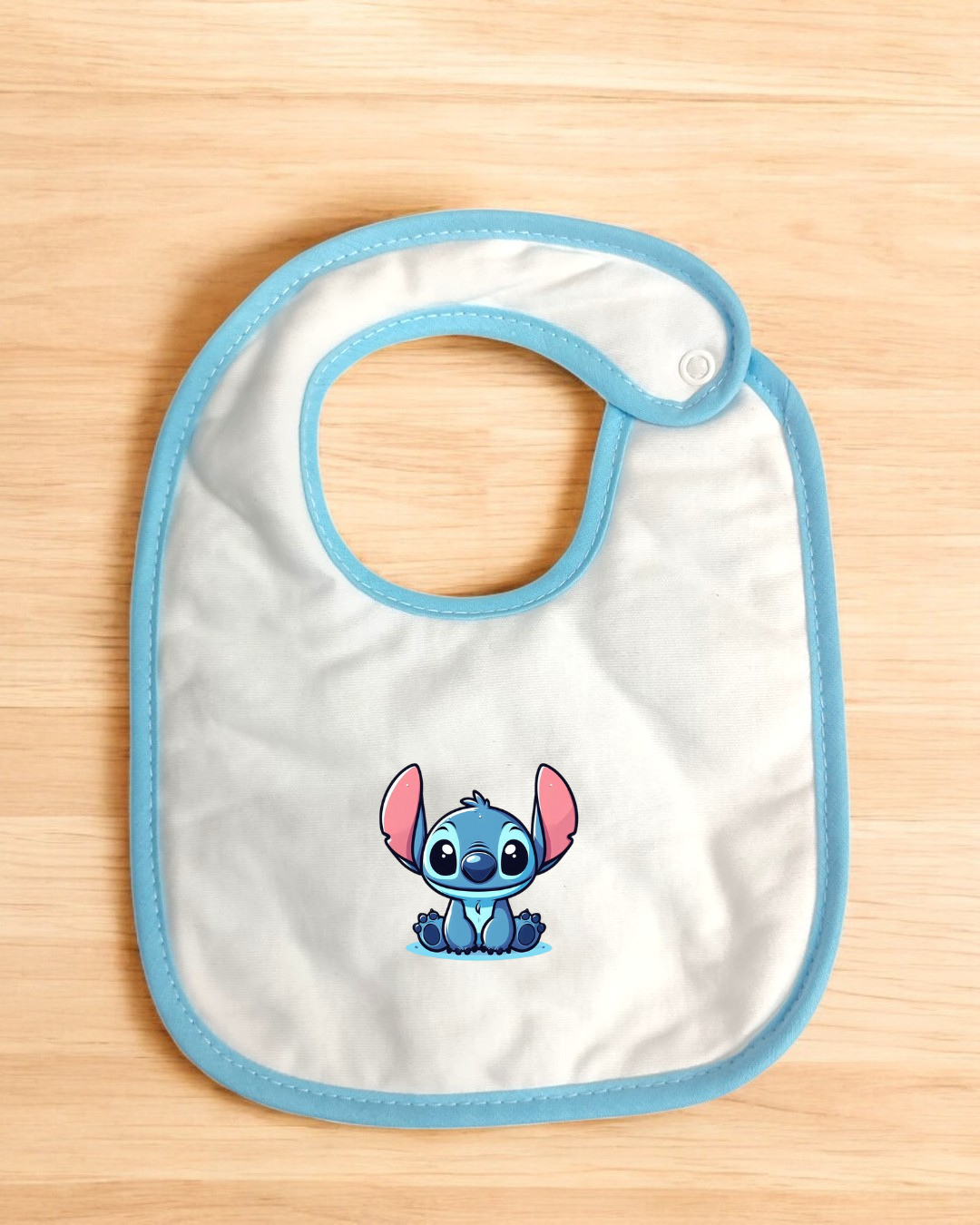 Babete branco com borda azul e estampa do personagem Stitch