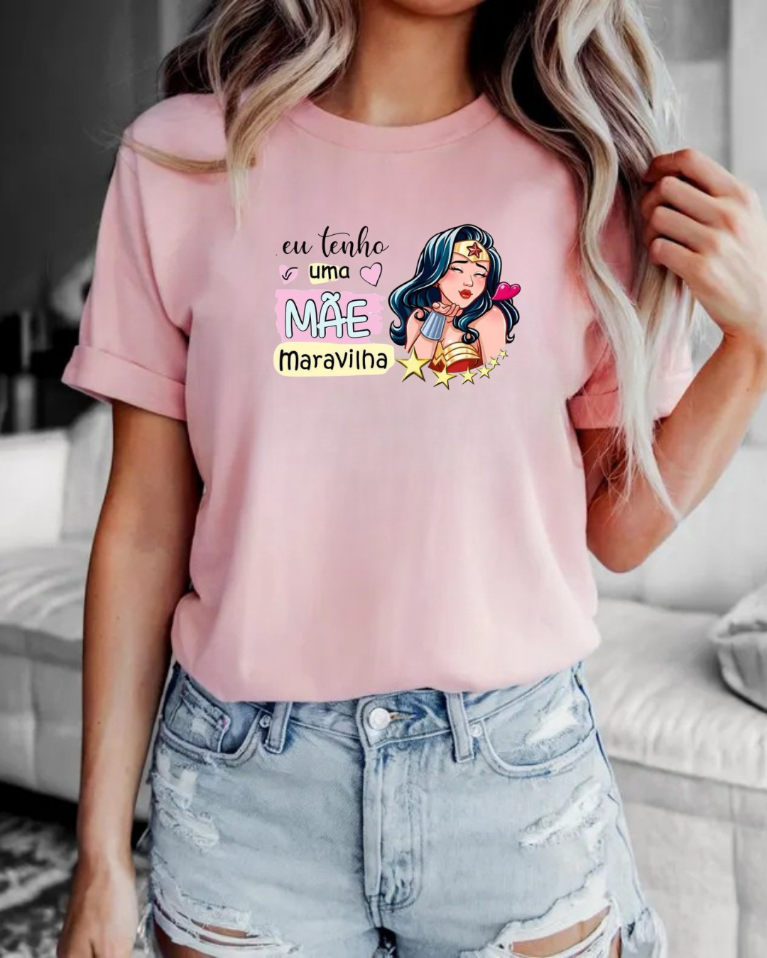 T-shirt rosa com estampado colorido e frase em português.