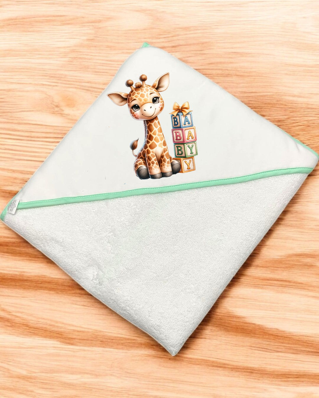 Toalha de bebé branca com borda verde claro e estampa de girafa com blocos coloridos