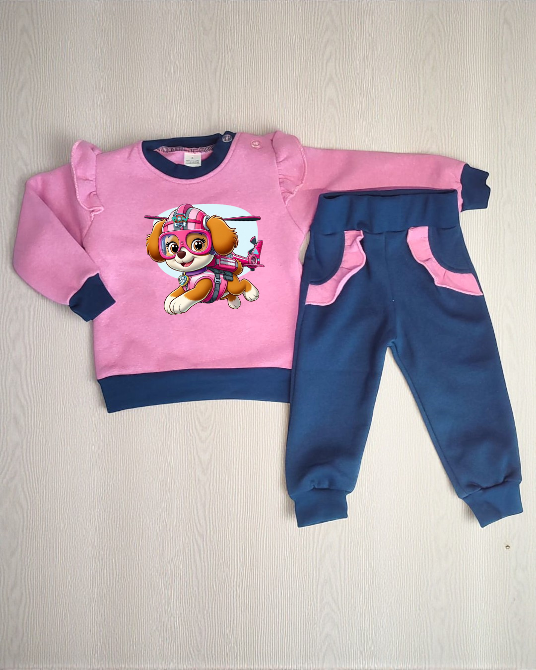 Conjunto de roupa infantil rosa e azul com estampa de personagem de desenho animado