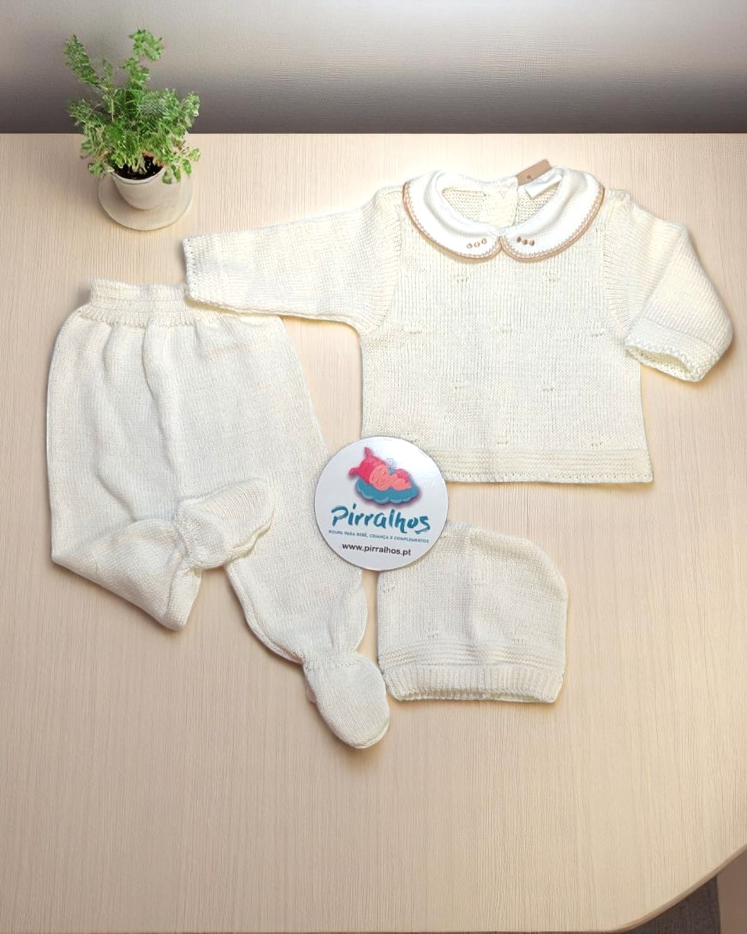 Conjunto de roupa de bebé branca em malha com casaco, calças, botins e gorro