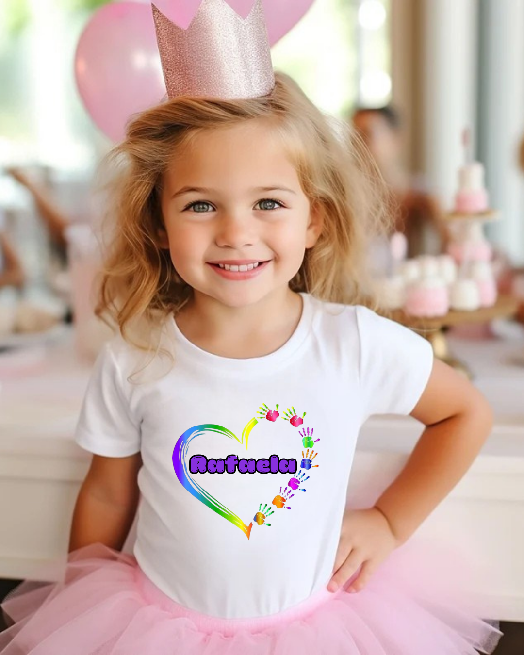 Camisola branca com estampa colorida e texto 'Rafaela' usada por criança em festa