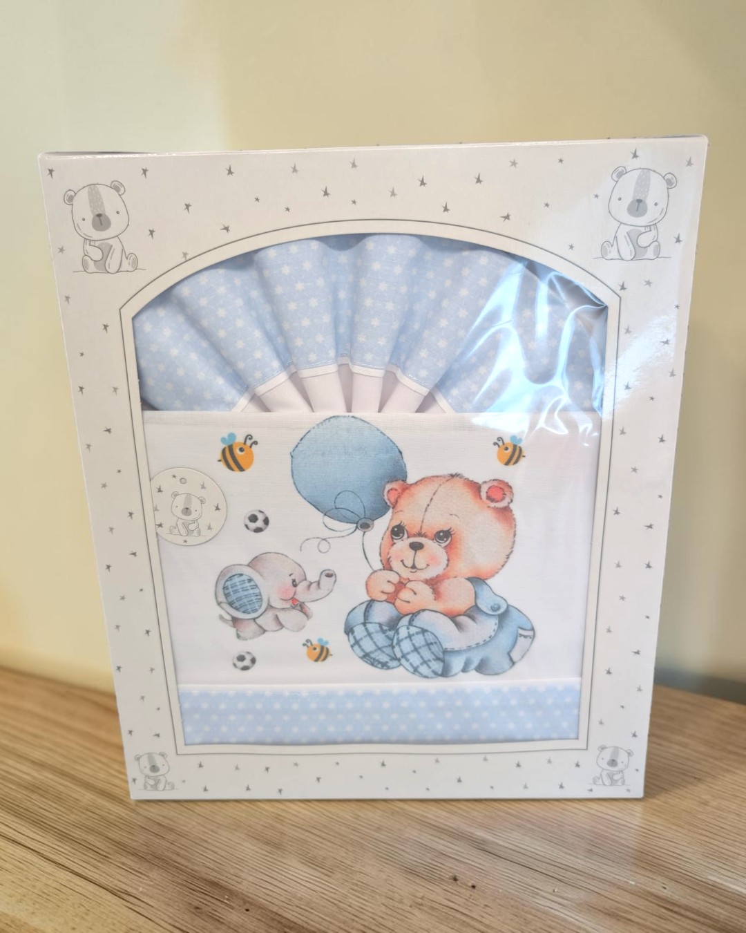Caixa de tecidos para bebé com padrões de estrelas e desenhos de urso e elefante.