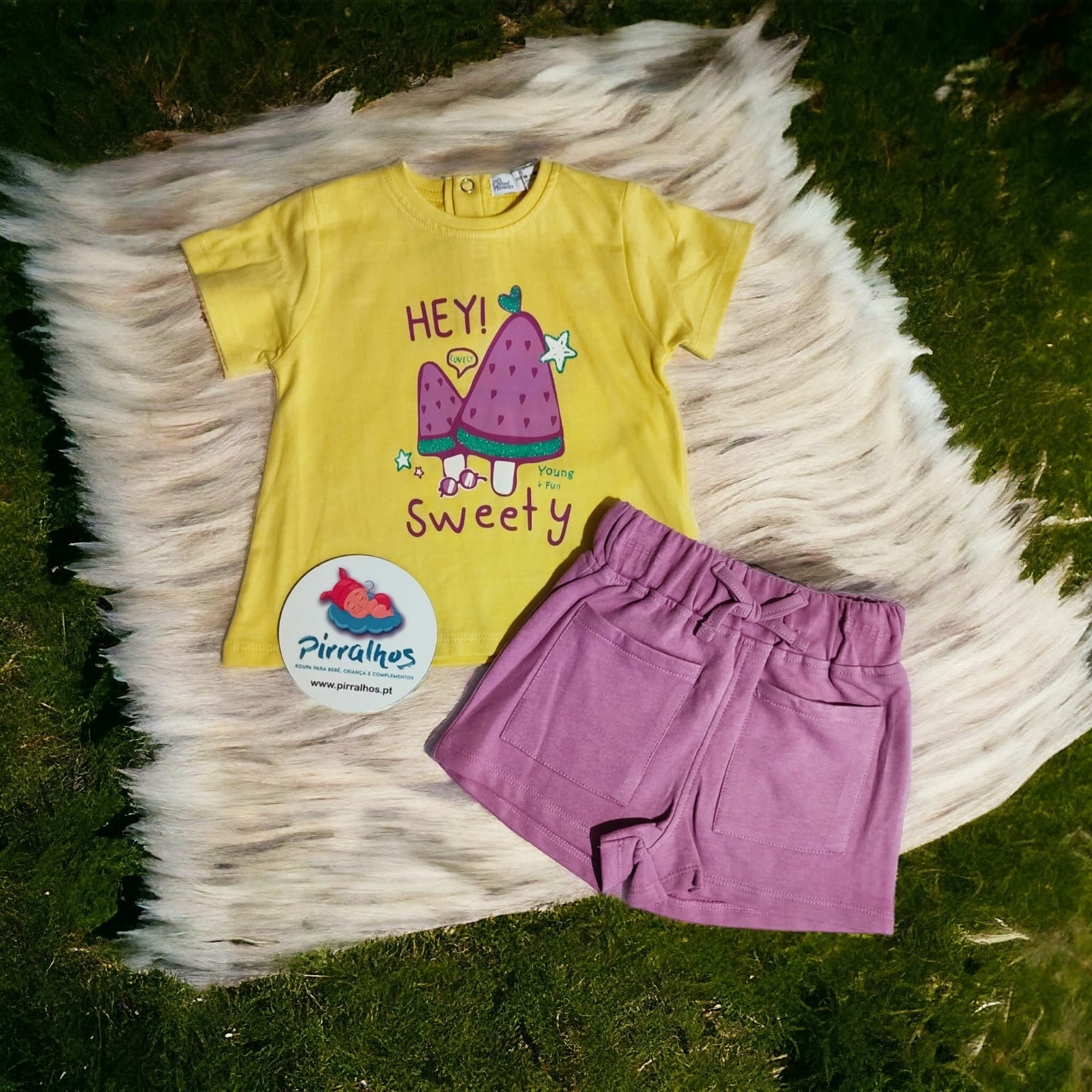 Conjunto infantil amarelo e rosa com estampa de sanduíche sobre tapete peludo branco