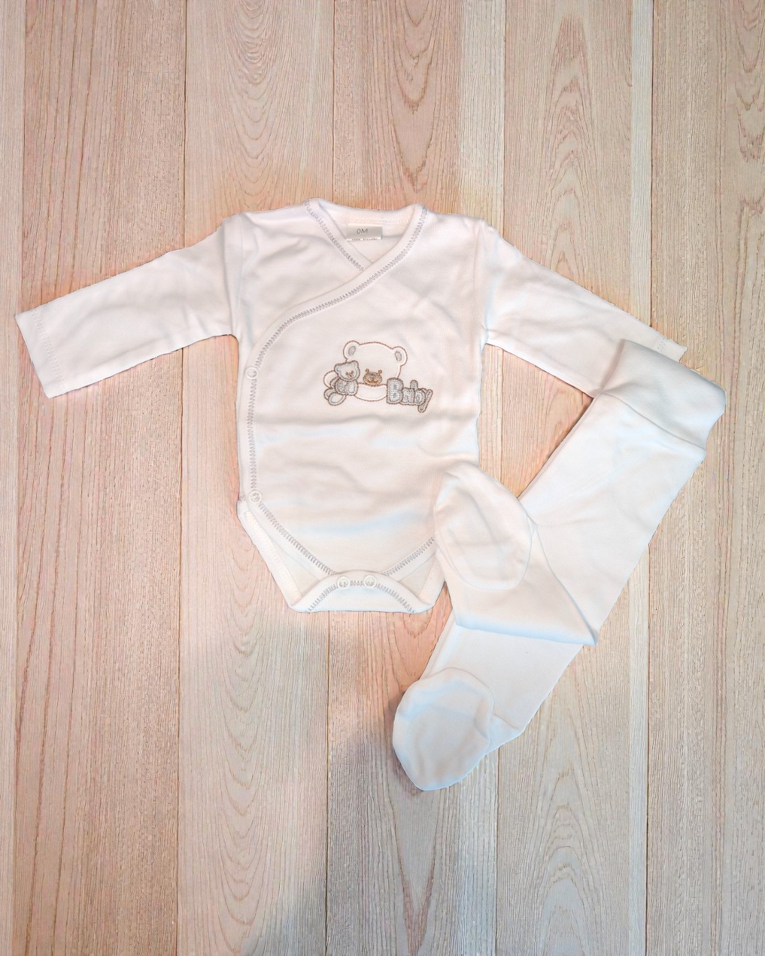 Conjunto branco de roupa de bebé com body e calças com pés