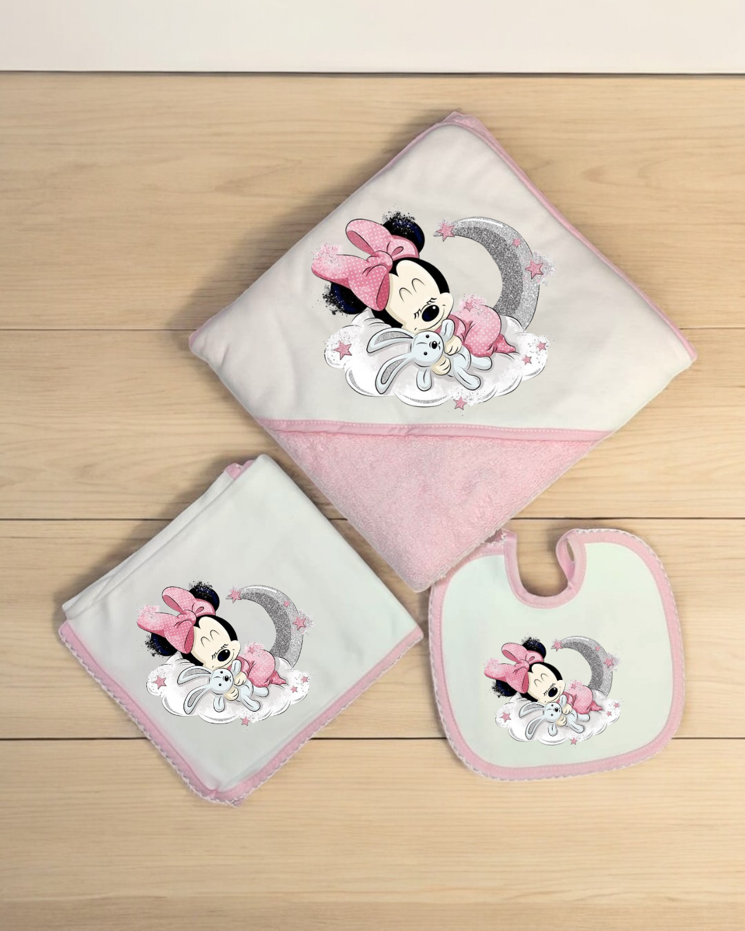 Conjunto infantil com toalha, fralda e babete bordados com a Minnie Mouse em rosa e cinza.