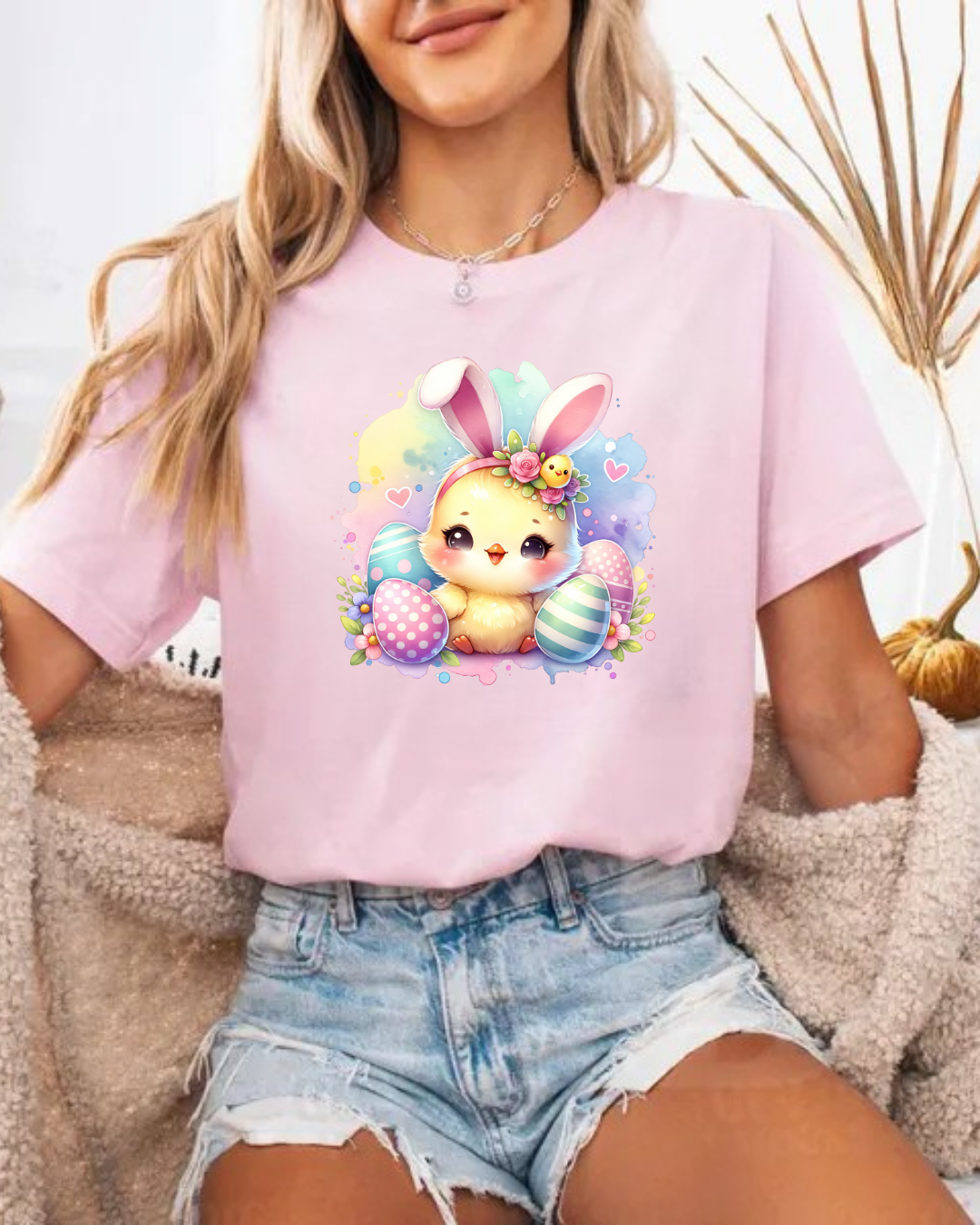 T-shirt rosa com estampa de coelho e ovos de Páscoa, usada com calções de ganga