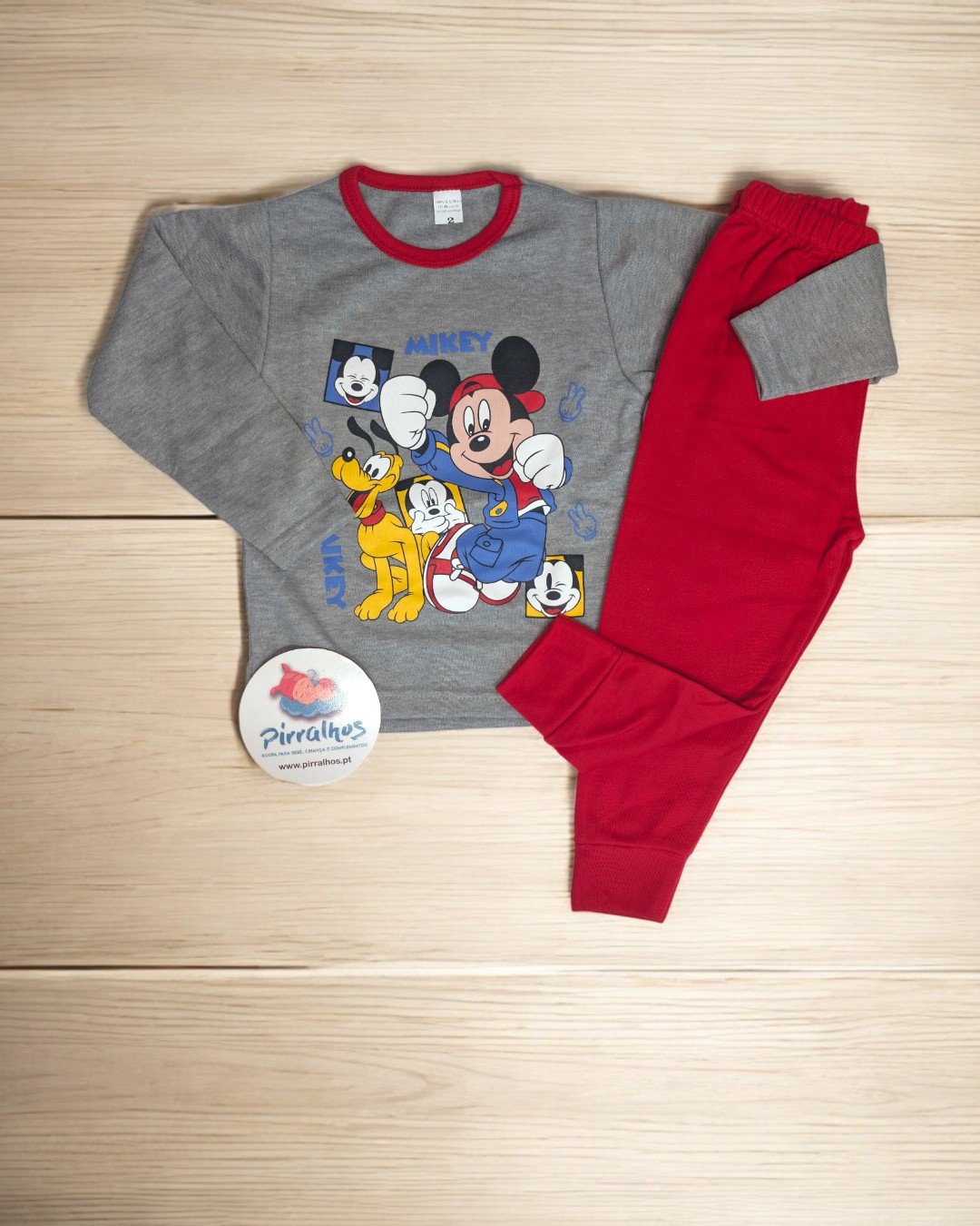pijama infantil Mickey cinza e vermelho com personagens Disney em fundo de madeira clara