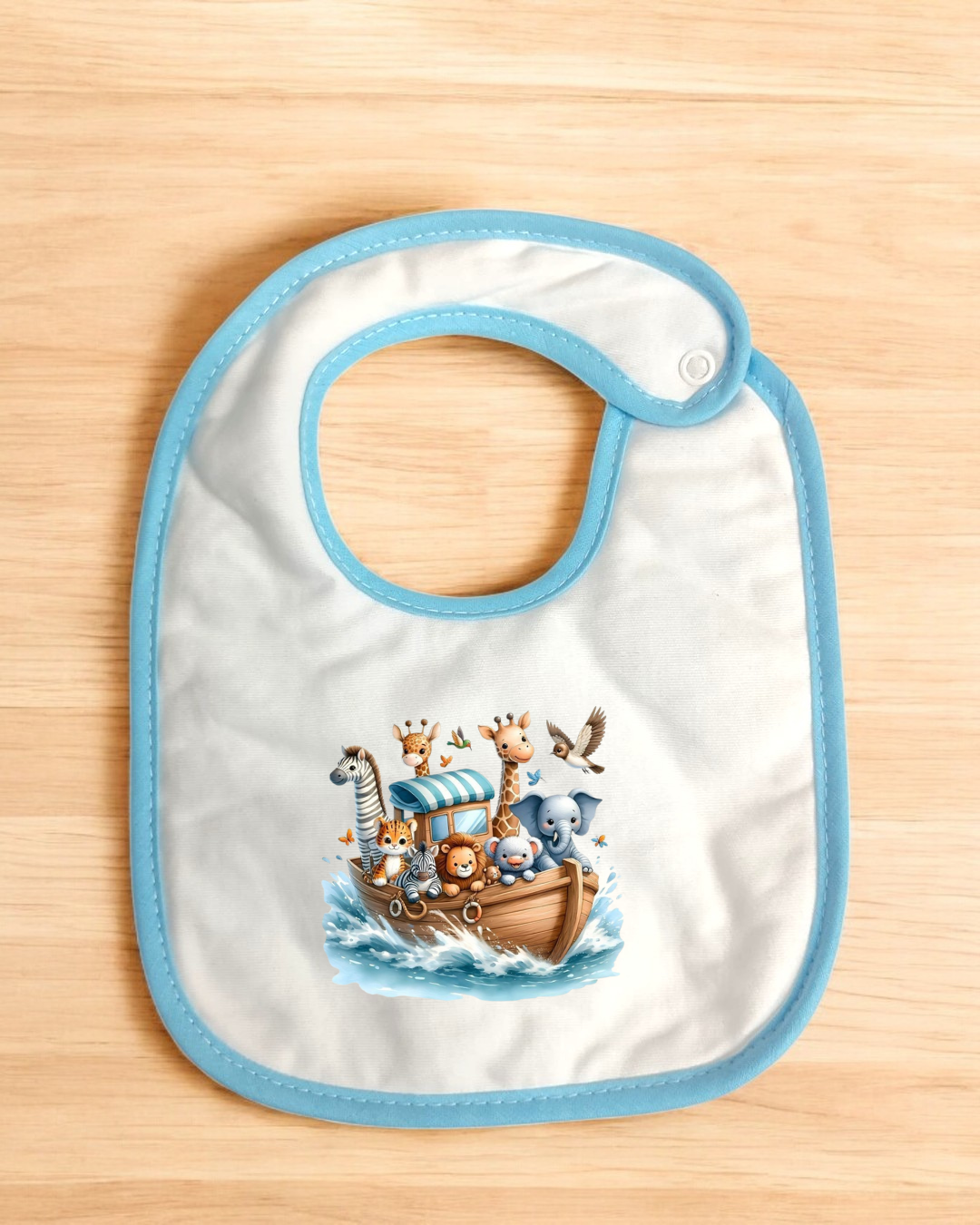 Babete branco com borda azul e ilustração de animais numa arca