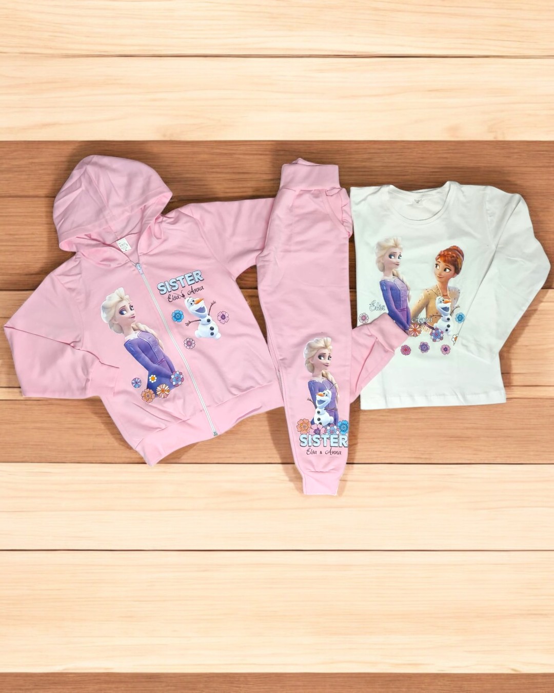 Conjunto infantil rosa e branco com estampados das personagens Elsa e Anna de Frozen