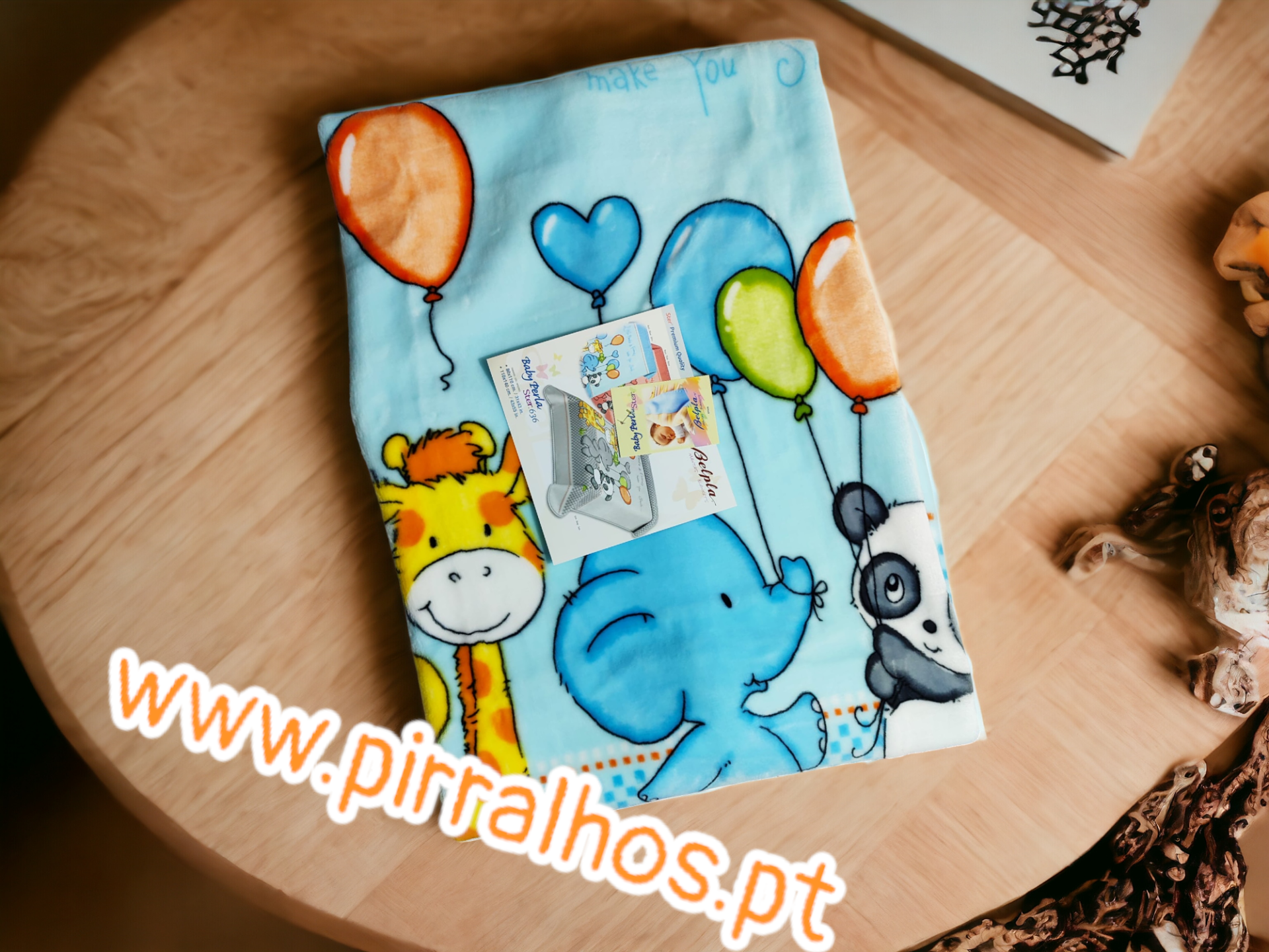 tecido azul com padrão de animais e balões coloridos em mesa de madeira clara