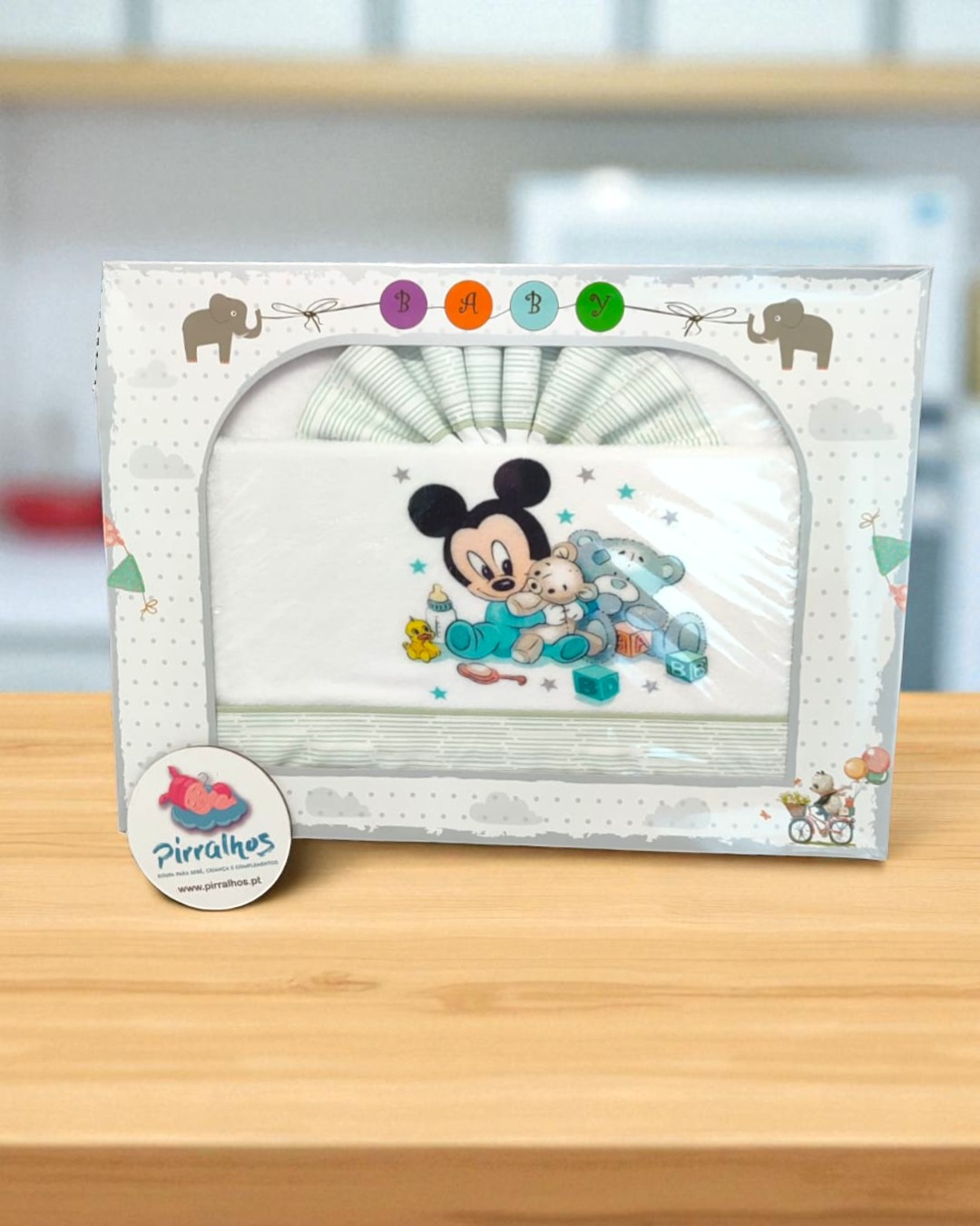 Conjunto de roupa de bebé com estampado do Mickey Mouse e brinquedos, na caixa com desenhos de elefantes