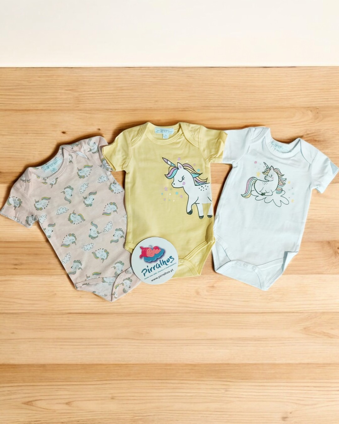 Três bodies de bebé coloridos com desenhos de unicórnios