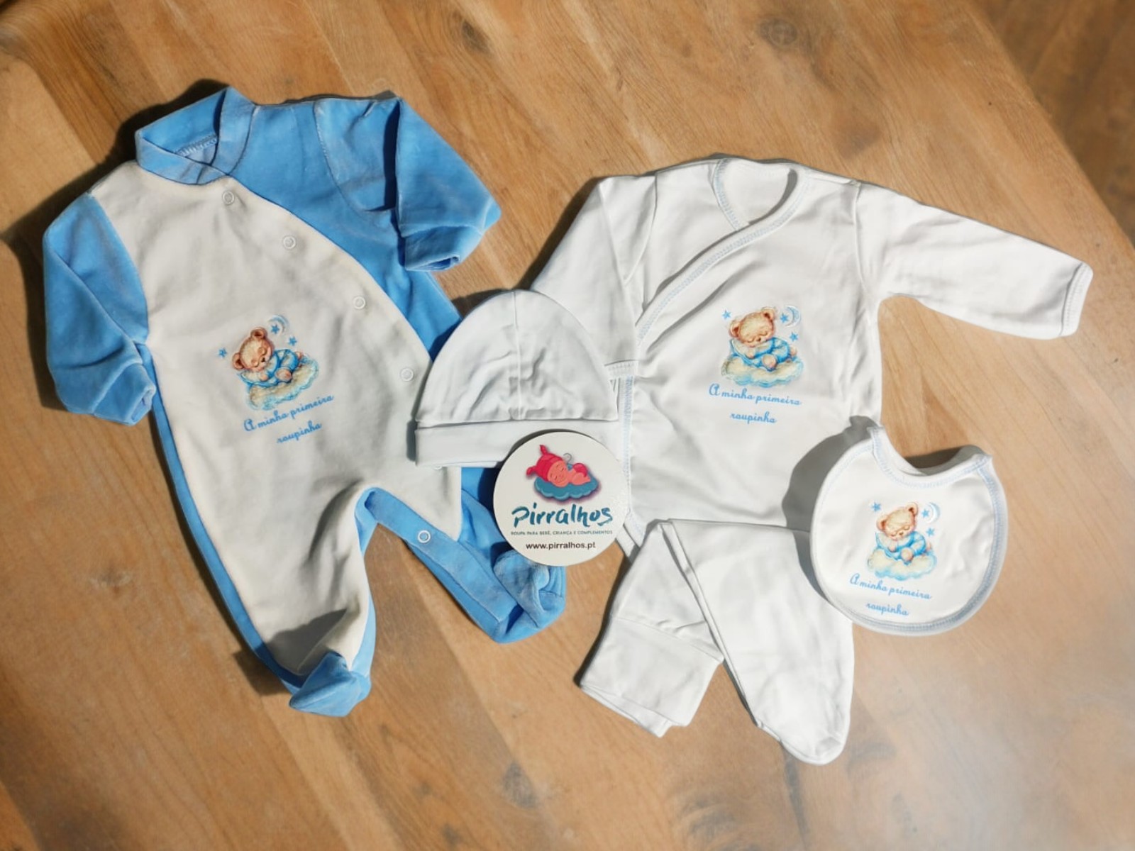 Conjunto de roupa de bebé azul e branco com ursinho e texto