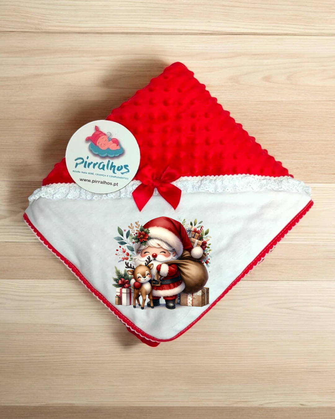 Manta de bebé vermelha e branca com estampa natalícia e etiqueta da marca Pirralhos