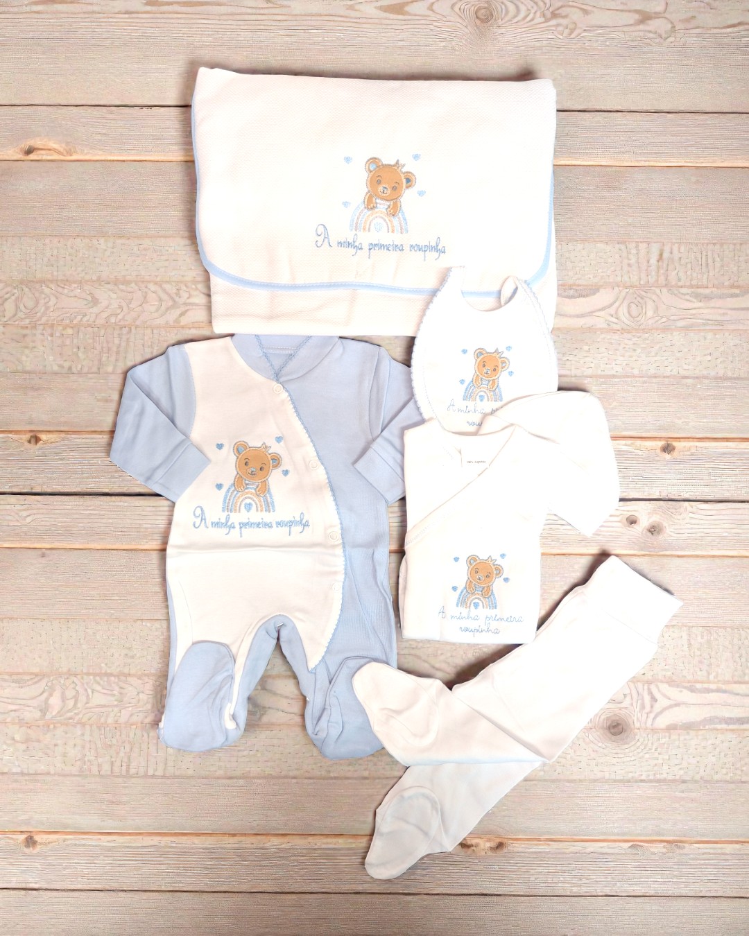 Conjunto de roupa de bebé azul e branco com bordados de urso e texto