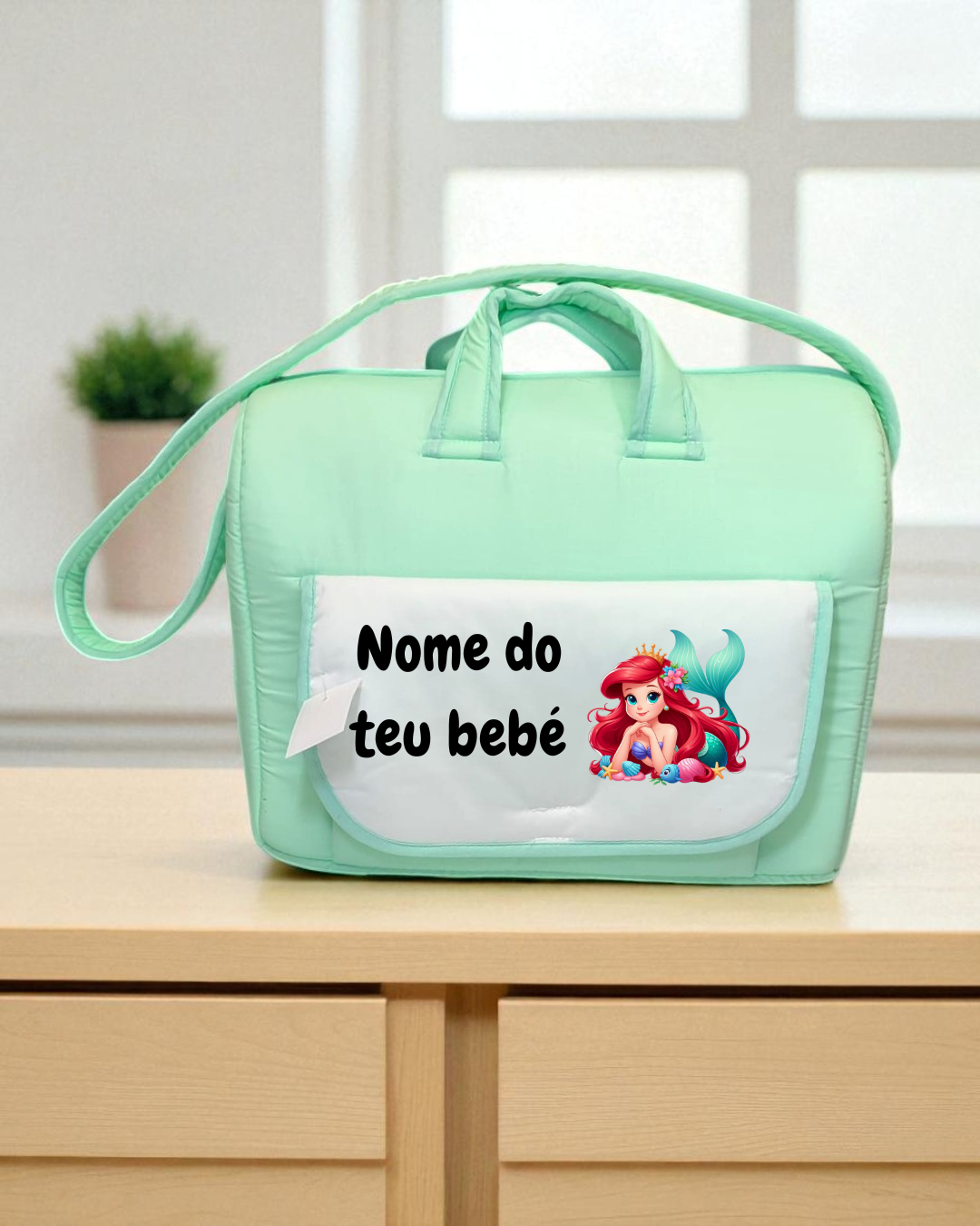 Mala de bebé verde claro com bolso branco e ilustração de sereia.