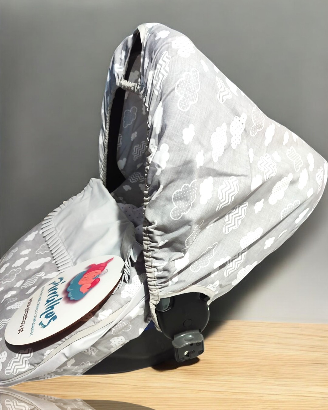 Capota de carrinho de bebé cinza com padrão de nuvens brancas e etiqueta redonda