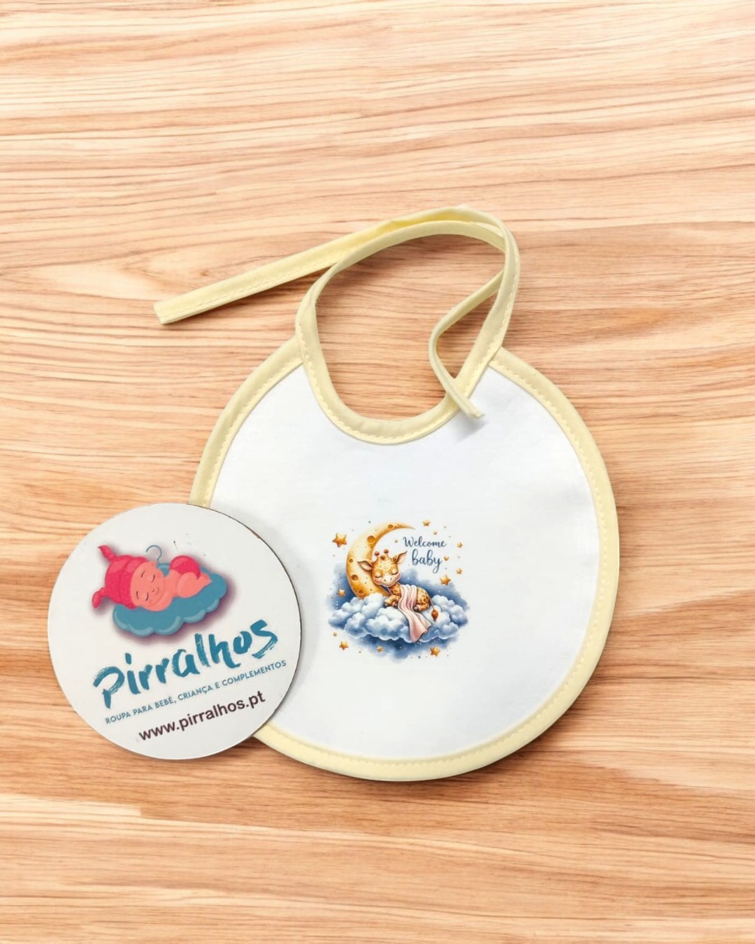 Babete de bebé branco com padrão de lua, estrelas e texto 'Welcome baby'