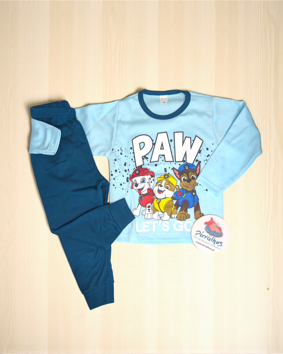 Pijama infantil azul com personagens Paw Patrol e calças azul escuras.