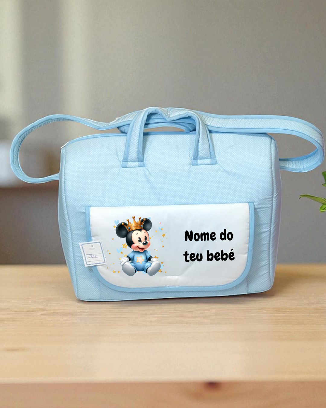 Mala de bebé azul clara com bolso frontal branco e imagem de rato com coroa