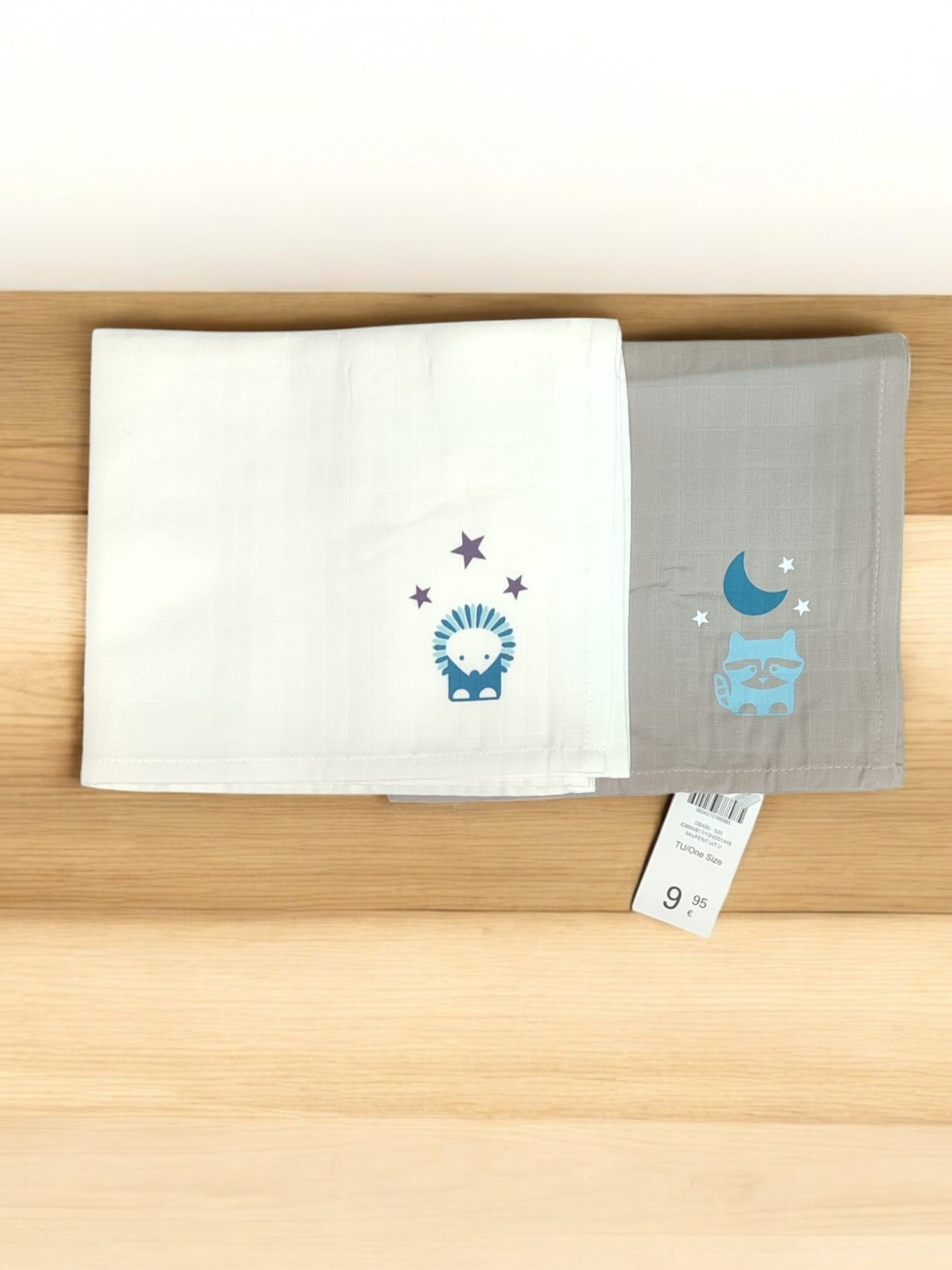 Conjunto de dois panos de cozinha com desenhos infantis em tecido branco e cinzento sobre mesa de madeira